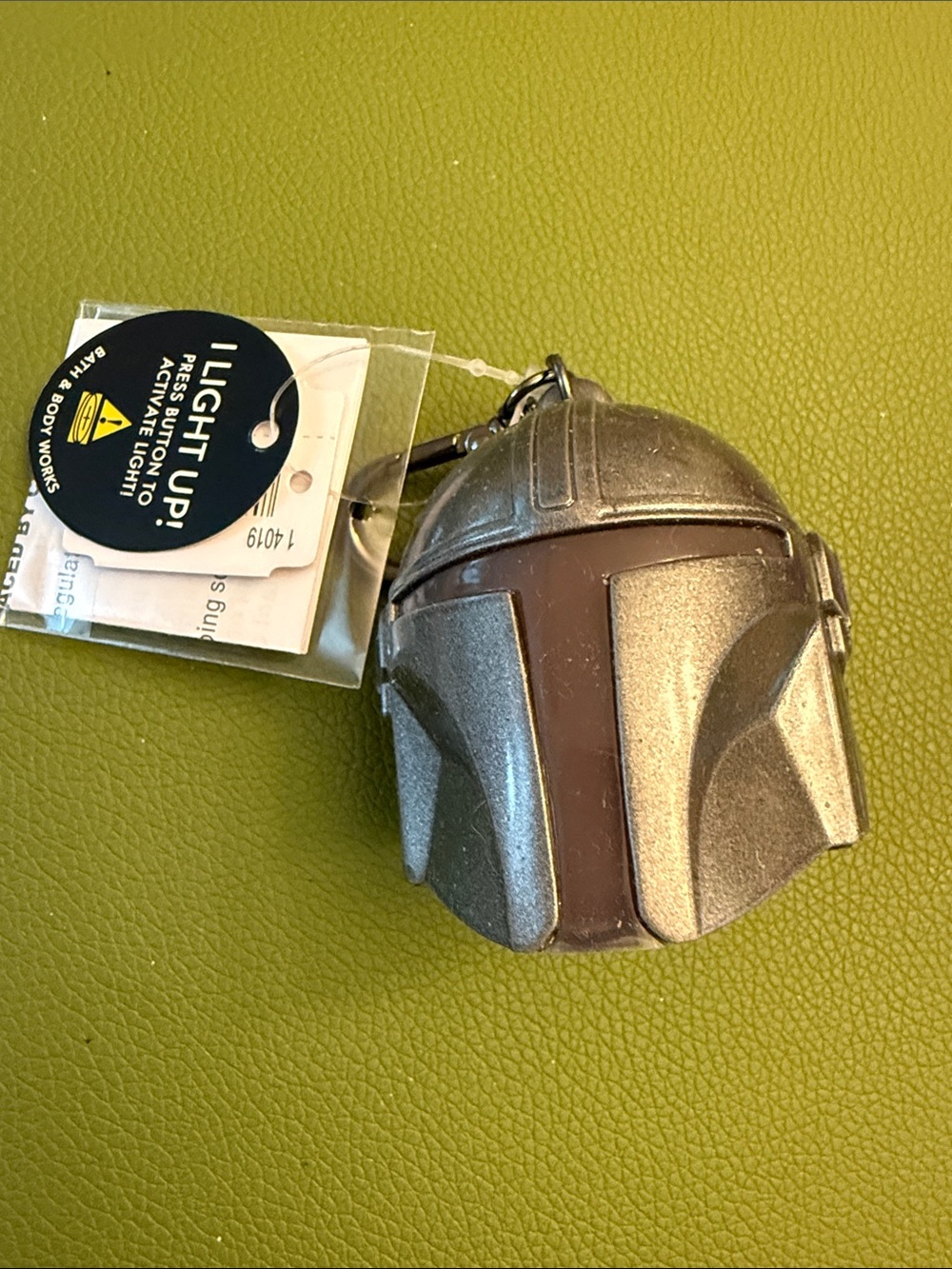 Mandalorian Helmet Keychain holds hand sanitizer that you provide. Lights up
